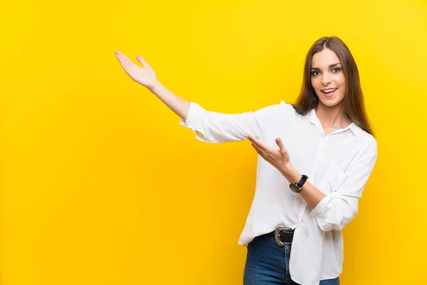 Young Woman Isolated Yellow Background Extending Hands Side Inviting Come — Stock Photo, Image