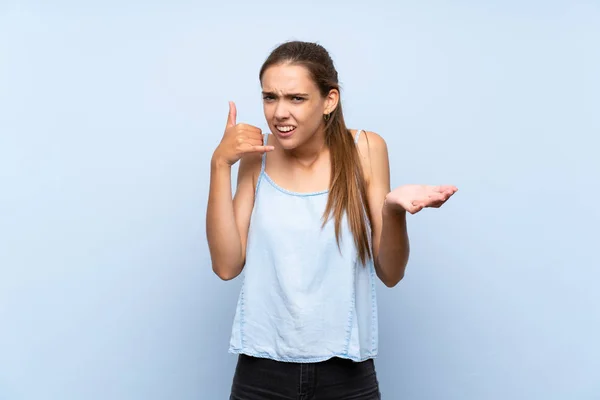 Jonge Vrouw Geïsoleerde Blauwe Achtergrond Maken Telefoon Gebaar Twijfelen — Stockfoto