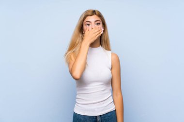 Izole mavi arka plan üzerinde Genç kız şaşırttı ve ok işareti gösteren