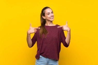 Soyutlanmış sarı arka plan gururlu ve kendini beğenmiş genç bir kadın.