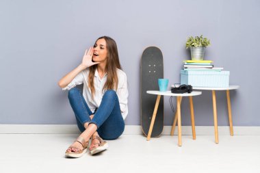 Genç bir kadın yerde oturuyor ve ağzı açık bağırıyor.