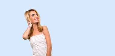 Genç sarışın kadın izole mavi arka plan üzerinde bir fikir düşünme