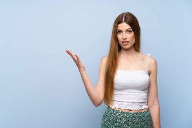 Izole mavi arka plan üzerinde genç kadın şüphe jest yapma