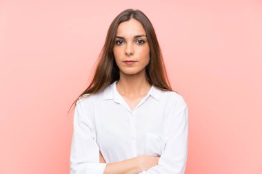 Izole pembe arka plan üzerinde genç kadın kollarını çapraz tutmak