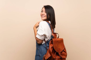 Sırt çantası ile izole arka plan üzerinde Genç Meksikalı kadın