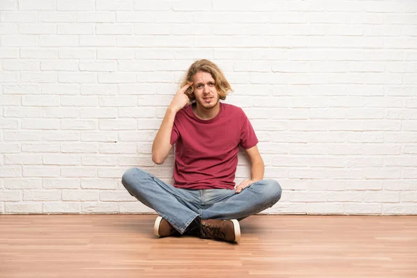 Blonde Man Zittend Vloer Maken Van Het Gebaar Van Waanzin — Stockfoto