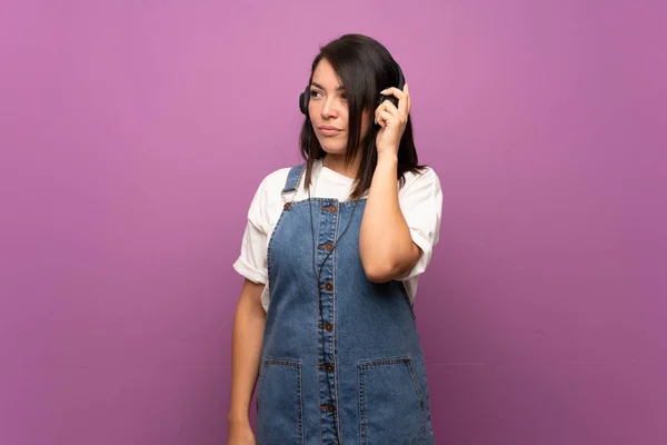Ung Mexikansk Kvinna Över Isolerad Bakgrund Lyssnar Musik Med Hörlurar — Stockfoto