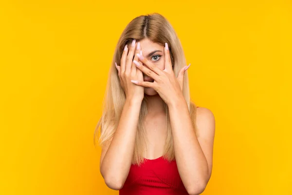 Dívka Izolovaném Žlutém Pozadí Zakrývající Oči Procházející Prsty — Stock fotografie
