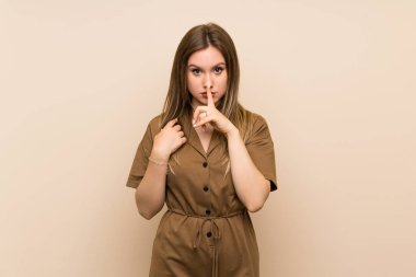 Izole arka plan üzerinde genç kız ağzına parmak koyarak sessizlik jest bir işareti gösteren