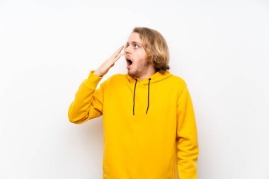 Beyaz duvar esneme ve el ile geniş açık ağız kapsayan üzerinde Sweatshirt ile sarışın adam