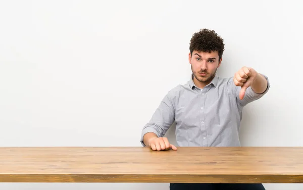 Jonge Man Met Een Tabel Met Duim Omlaag Met Negatieve — Stockfoto