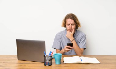 Bir laptop düşünme ve bir mesaj gönderme ile sarışın adam