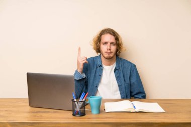 Bir dizüstü bilgisayar ile sarışın adam Dizin parmak büyük bir fikir işaret