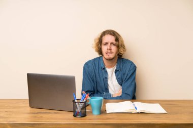 Bir laptop ile sarışın adam şüpheler ve yüz ifadesi karıştırmaya sahip