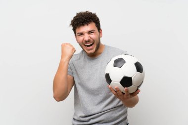 Bir futbol topu tutan izole duvar üzerinde kıvırcık saçlı adam