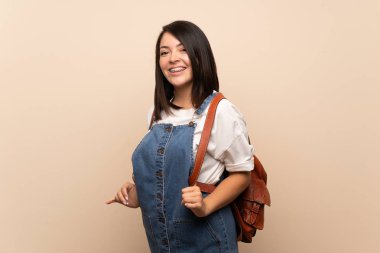 Sırt çantası ile izole arka plan üzerinde Genç Meksikalı kadın