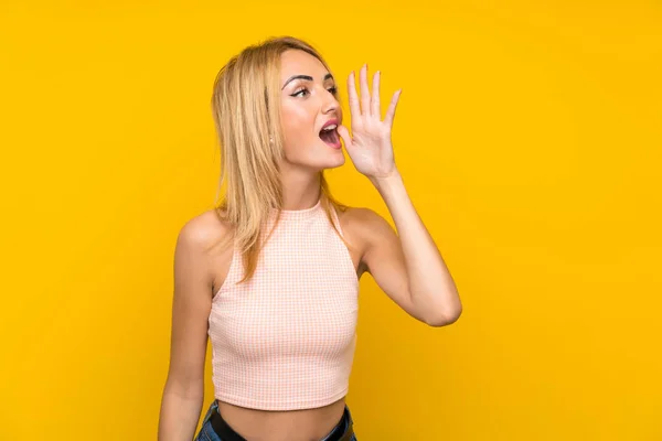 Joven Rubia Sobre Aislada Pared Amarilla Gritando Con Boca Abierta —  Fotos de Stock