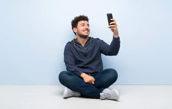 Junger Mann Sitzt Auf Dem Boden Und Macht Ein Selfie — Stockfoto