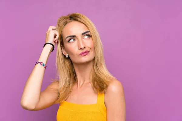 Young Blonde Woman Purple Background Having Doubts Confuse Face Expression — Stock Photo, Image