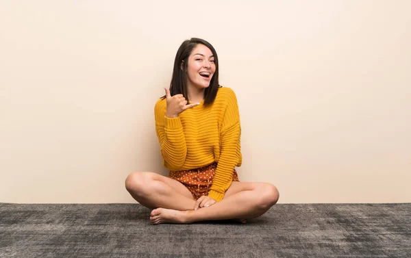 Young Mexican woman making phone gesture