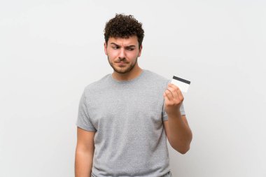 Bir kredi kartı tutan izole duvar üzerinde kıvırcık saçlı adam