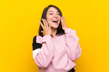 Sürpriz yüz ifadesi ile izole sarı arka plan üzerinde Genç Meksikalı kadın