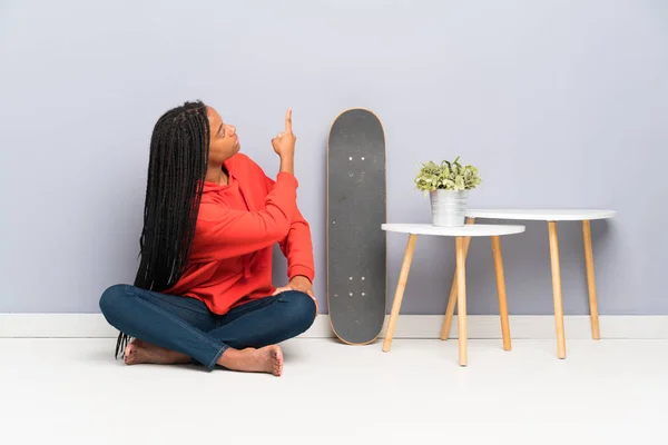 Niña Adolescente Patinadora Afroamericana Con Pelo Trenzado Sentado Suelo Apuntando — Foto de Stock