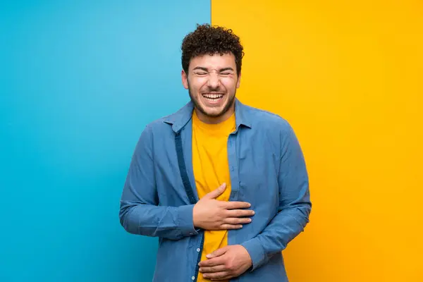 Mann Mit Lockigem Haar Über Bunter Wand Lächelt Viel — Stockfoto