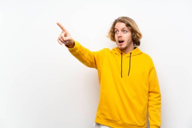 Beyaz duvar üzerinde Sweatshirt ile sarışın adam uzağa işaret