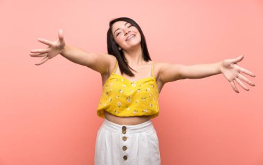 Izole duvar üzerinde genç Meksikalı kadın sunan ve el ile gelmek için davet