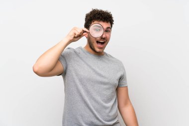 Bir büyüteç tutan izole duvar üzerinde kıvırcık saçlı adam