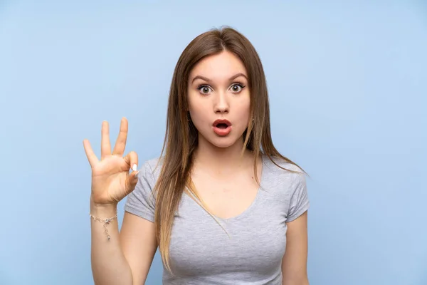 Ragazza Adolescente Oltre Isolato Muro Blu Sorpreso Mostrando Segno — Foto Stock