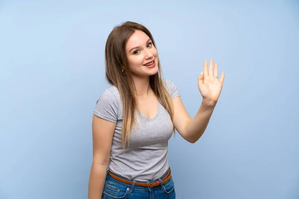 Adolescente Chica Sobre Aislado Azul Pared Saludo Con Mano Con — Foto de Stock