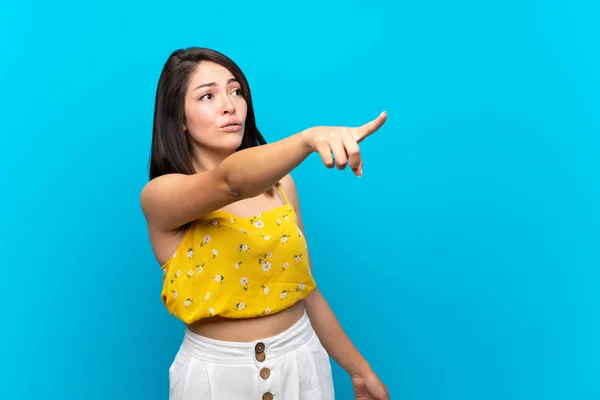 Jovem Mexicana Sobre Isolado Fundo Azul Apontando Para Longe — Fotografia de Stock