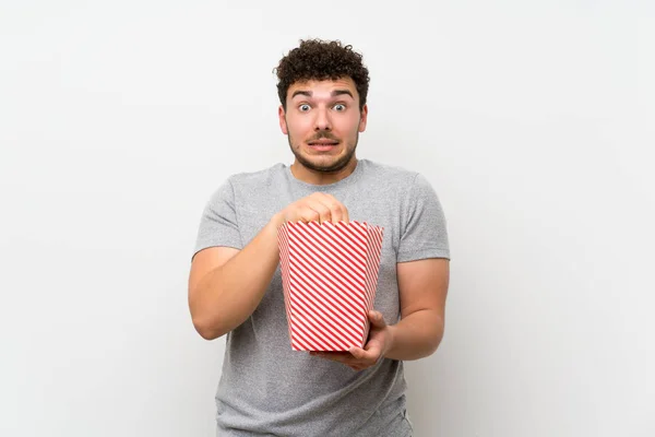 Homme Aux Cheveux Bouclés Sur Mur Isolé Mangeant Des Popcorns — Photo