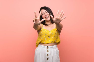 Izole duvar üzerinde genç Meksikalı kadın parmakları ile sekiz sayma