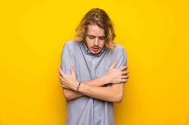 Sarışın adam üzerinde izole sarı arka plan donma