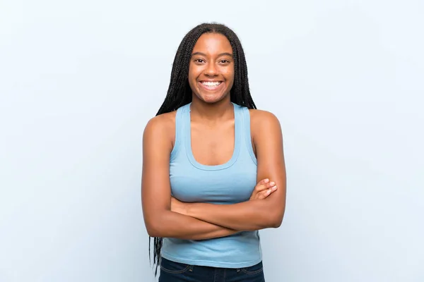 非裔美国青少年女孩与长辫子的头发在孤立的蓝色背景笑 — 图库照片
