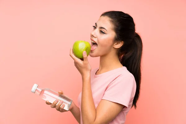 Teenager Mädchen Über Isolierte Rosa Wand Mit Einer Flasche Wasser — Stockfoto