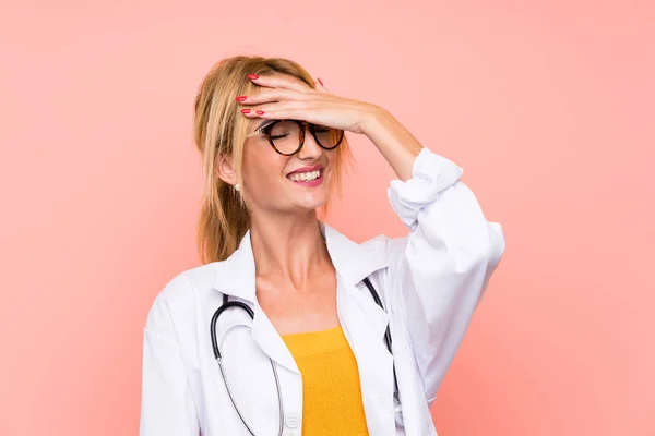 Young blonde doctor woman laughing