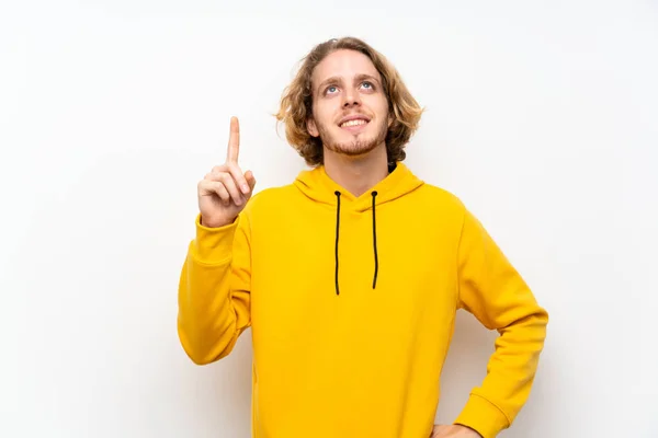 Blond Man Med Sweatshirt Över Vit Vägg Visa Och Lyfta — Stockfoto