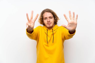 Beyaz duvar üzerinde Sweatshirt ile sarışın adam parmak sekiz sayma