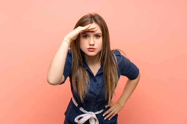 Tonårstjej Över Isolerad Rosa Bakgrund Ser Långt Bort Med Handen — Stockfoto