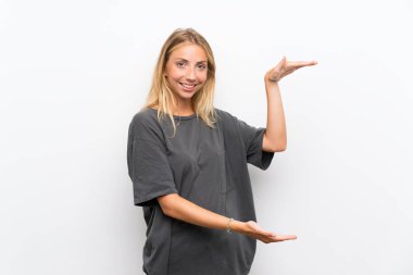 Bir reklam eklemek için copyspace tutarak izole beyaz arka plan üzerinde Sarışın genç kadın