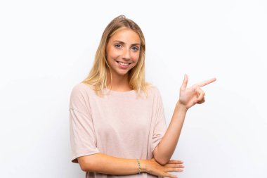 Izole beyaz arka plan yan parmak işaret üzerinde Sarışın genç kadın
