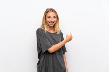 Izole beyaz arka plan üzerinde Sarışın genç kadın geri işaret