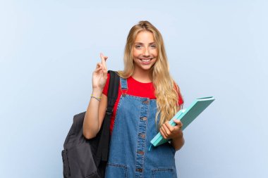 Parmakları geçiş ile izole mavi duvar üzerinde genç sarışın öğrenci kadın