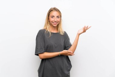 Sarışın genç kadın izole beyaz arka plan üzerinde gelmeye davet için yan ellerini uzatan