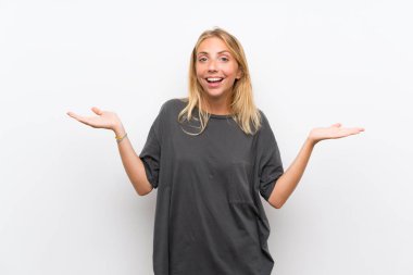 Şok yüz ifadesi ile izole beyaz arka plan üzerinde Sarışın genç kadın