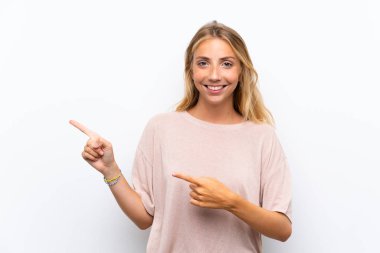 Izole beyaz arka plan yan parmak işaret üzerinde Sarışın genç kadın